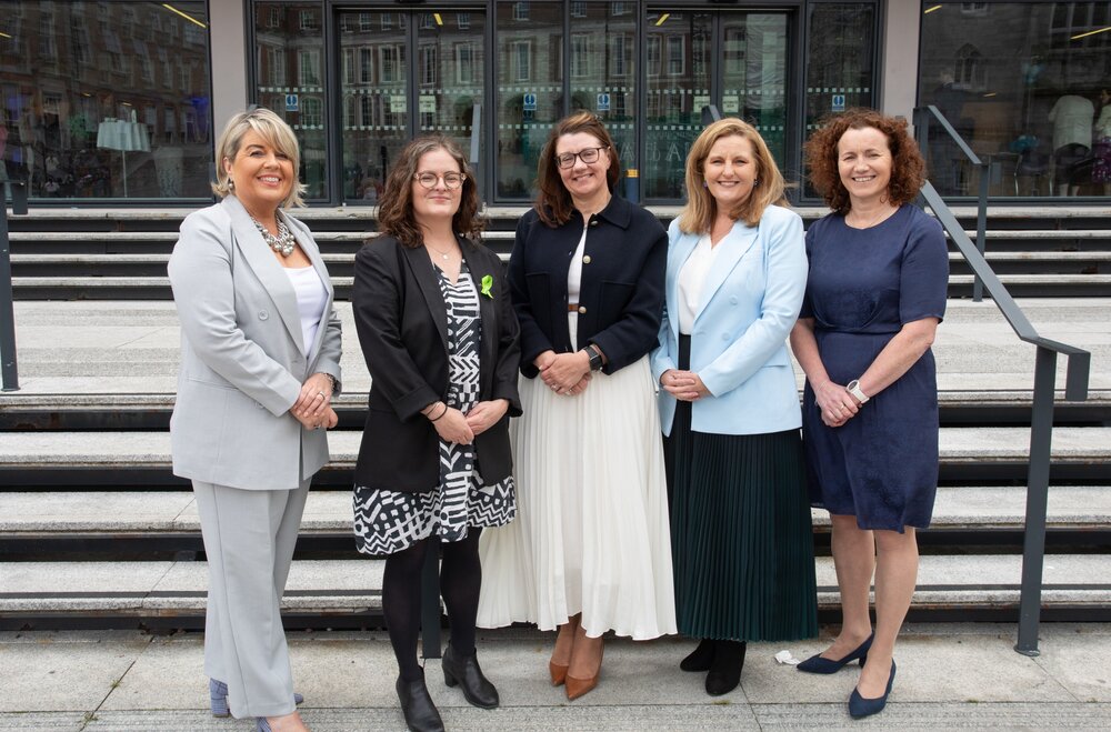 A group of women standing in front of a buildingDescription automatically generated