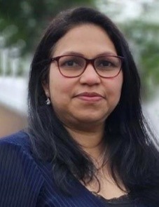 A person with long black hair wearing glassesDescription automatically generated